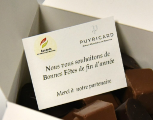 Boîte de chocolats offerte par la chocolaterie Puyricard à l’Association Accords avec un message de vœux de fin d’année, symbole du partenariat entre l’association et le chocolatier d’Aix-en-Provence
